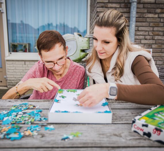 Een man en vrouw leggen samen een puzzel