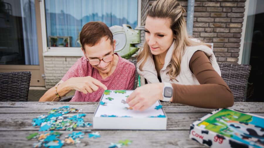 Een man en vrouw leggen samen een puzzel